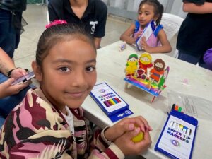 child shows off her craft for the one who rescues on a mission trip in costa rica