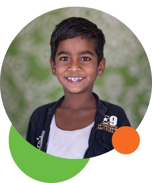 Boy in South Asia, smiling thanks to the help through One More Child's feeding program